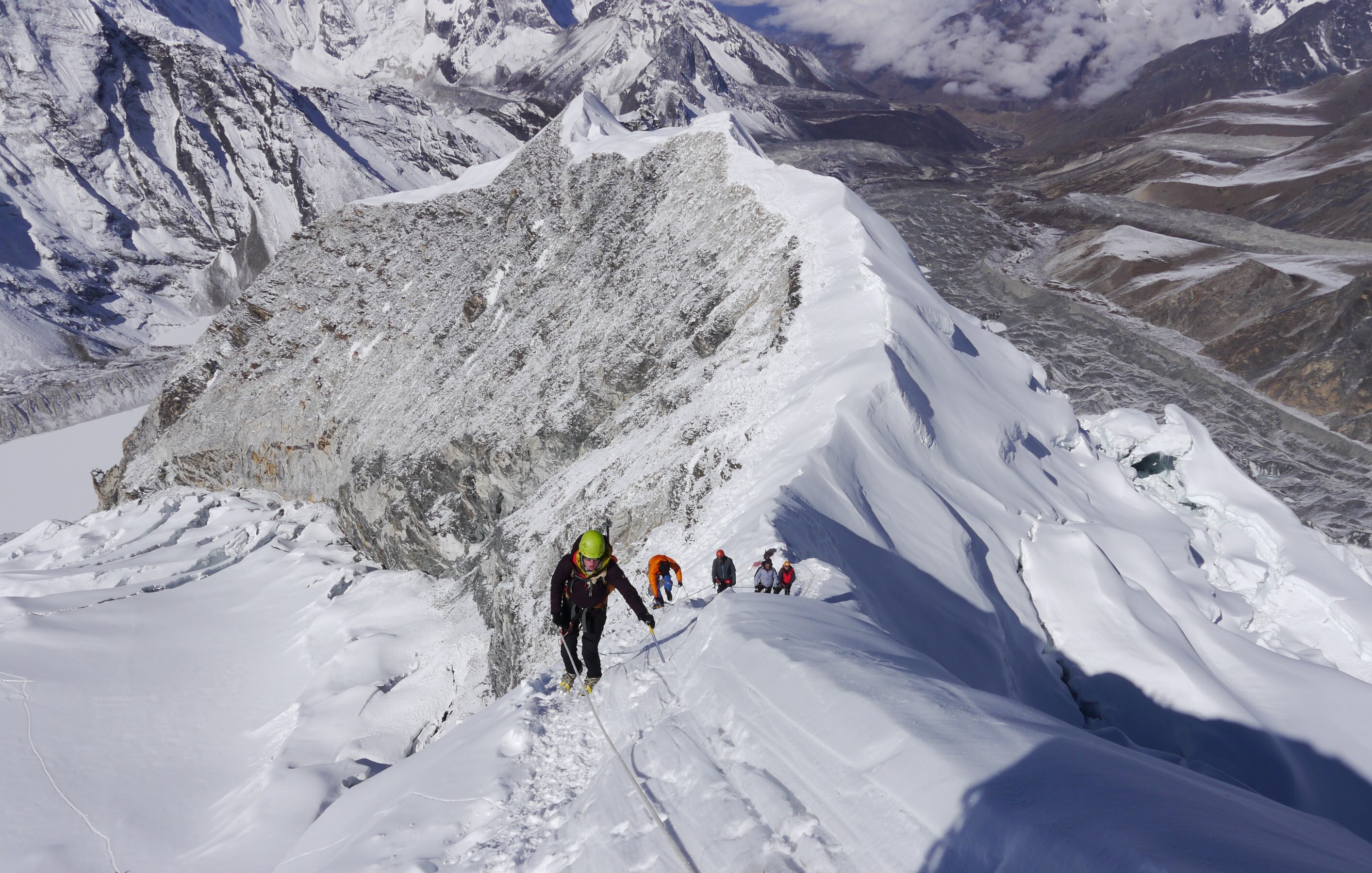 A hiker overlooking a snowy European mountain range